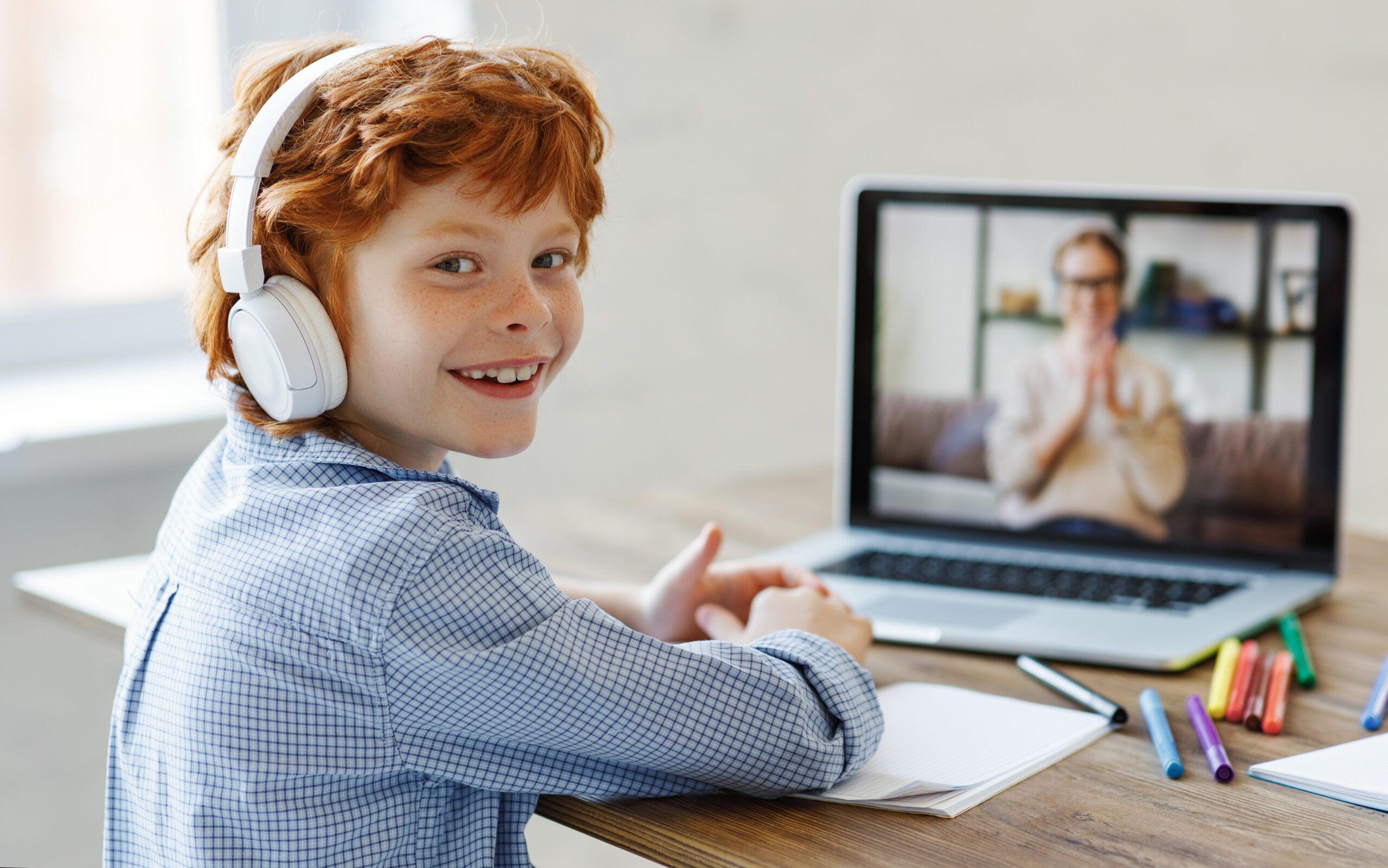 Smiling student learning online with headphones