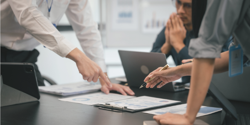 Special education professionals reviewing IEP documents and compliance records during a case management meeting.